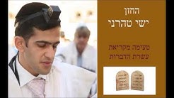 החזן ישי טהרני כשלראשו תפילין והוא בחליפה לבנה בבית כנסת